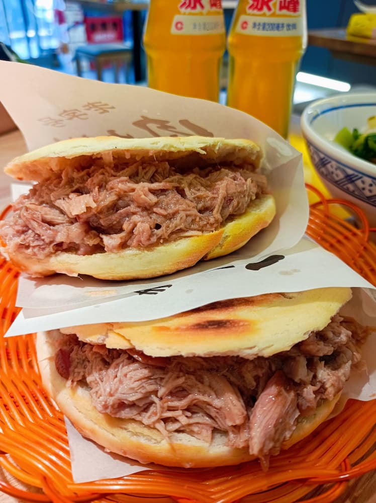 Authentic Xi'an Roujiamo: Crispy baked bun stuffed with tender braised pork, Chinese street food.