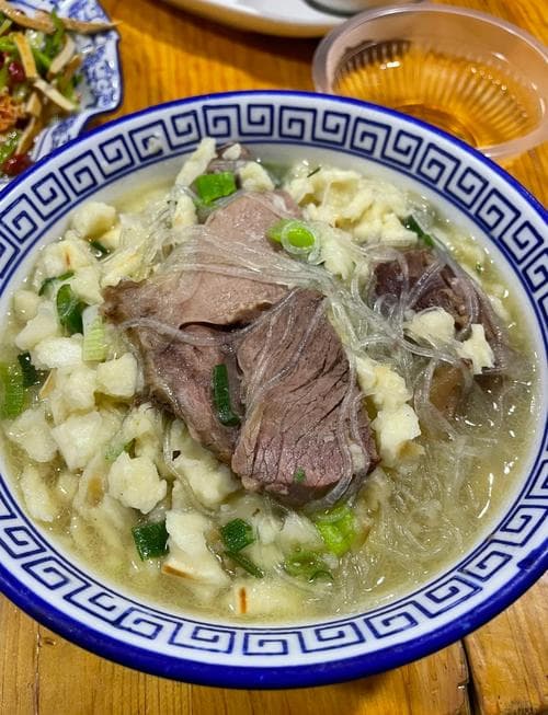 Authentic Xi'an Yangrou Paomo: Hand-torn bread in rich lamb soup, Shaanxi's iconic dish.